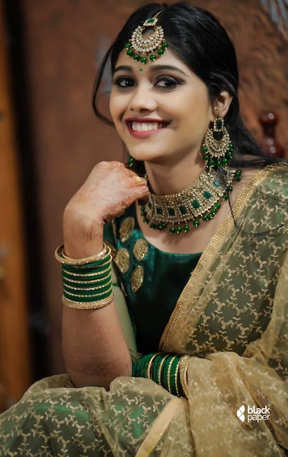 Good looking bride dressed in a green lehenga for reception